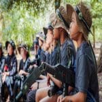 school group with laser guns and combat gear in a wooded forest