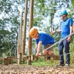 school pupils on a low ropes course in the countryside