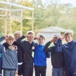 group of primary pupils waving at the camera