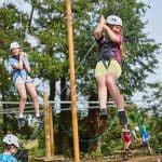 school pupils doing high ropes on a climbing frame course