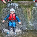 primary school child with safety and wetsuit in the water