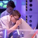 school pupil at science centre looking in a interactive microscope station
