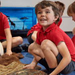primary school pupils looking at animal artifacts such as tusks and animal hides